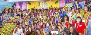 Foule de femmes africaines souriantes, poings en l'air en signe de solidarité