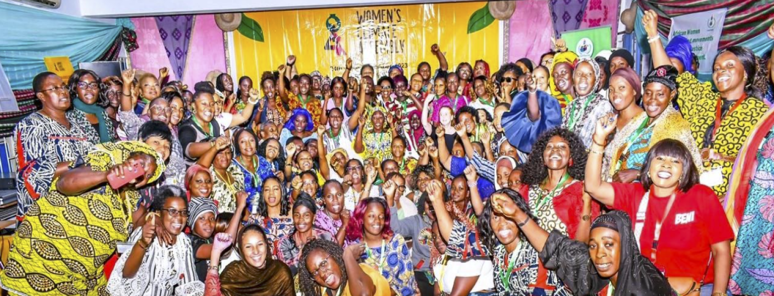 Skare Afrikaanse Vroue glimlag met vuiste in die lug in solidariteit